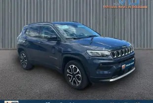 Jeep Compass bleu en 3/4 avant droit, avec barres de toit et jantes 18 pouces visibles sur fond neutre.