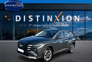 Hyundai Tucson 1.6 t-gdi 239 hybride vert en 3/4 avant droit devant un showroom Distinxion.