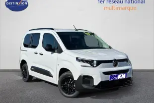 Vue 3/4 avant droite d'un Citroën Berlingo blanc 2025 avec jantes noires et protections latérales noires.