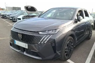 Vue 3/4 avant droite d’un Peugeot 3008 gris 2025 avec calandre noire et feux LED distinctifs en griffes.