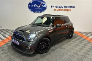 Vue 3/4 avant droite d'une MINI Cooper gris foncé avec jantes noires et toit ouvrant en studio showroom.