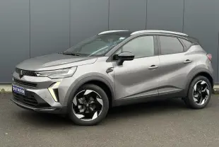 Renault Captur 2025 gris Cassiopée et noir, vue 3/4 avant droit avec jantes alu noires diamantées et railing de toit alu.