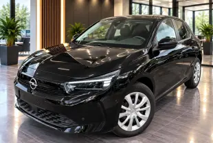 Opel Corsa 2025 noir karbon vue 3/4 avant en intérieur, avec jantes argentées et phares LED distinctifs.