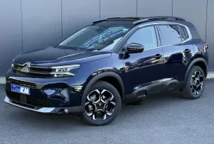 Citroën C5 Aircross Bleu Eclipse en 3/4 avant droit, avec jantes alliage bi-ton et barres de toit noires.