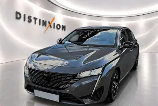 PEUGEOT 308 gris selenium en vue 3/4 avant droit, avec calandre noire et feux LED distinctifs.