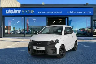 Vue 3/4 avant d'une Ligier JS50 Select Revo D+ blanc glacier avec calandre noire et jantes noires devant un showroom.