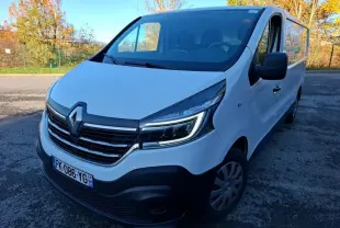 Renault Trafic Fourgon blanc vu en 3/4 avant droit, avec calandre noire et phares LED allumés.