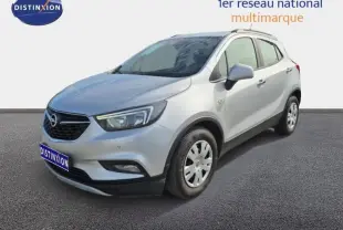 Opel Mokka X gris minéral vu en 3/4 avant droit, avec barres de toit et jantes acier.