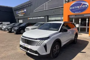 Peugeot 5008 Hybrid blanc Okénite en 3/4 avant droit, avec calandre distinctive et jantes alu, devant un concessionnaire.