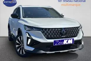 Renault Austral blanc nacré en 3/4 avant droit, avec calandre noire à motif géométrique et feux LED distinctifs.