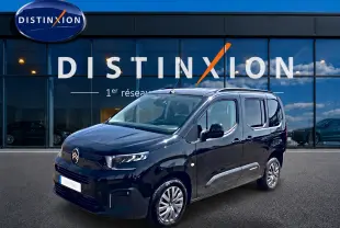 Citroën Berlingo noir vue 3/4 avant droit, avec barres de toit et poignées ton carrosserie visibles.