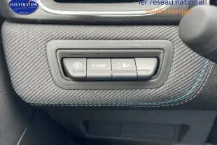 Gros plan sur les commandes E-Save et réglage des phares sur tableau de bord en tissu gris avec surpiqûres bleues.