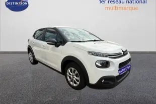 Citroën C3 blanc vue 3/4 avant droit, avec détails noirs contrastants sur les rétroviseurs et protections basses.