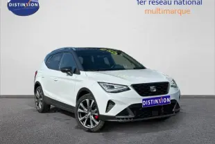 SEAT Arona 2025 blanc Candy avec toit noir Minuit, vue 3/4 avant droit mettant en valeur les jantes alliage et calandre noire.
