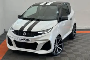 Vue 3/4 avant droite d'une Aixam Ambition 0.5 City GTO blanche avec bandes noires et jantes noires à rayures argentées.