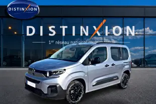 Vue 3/4 avant droit du Citroën Berlingo 2026 gris acier avec jantes noires et protections latérales noires.