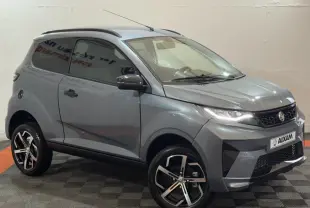 Vue 3/4 avant d'une Aixam Ambition 0.5 Crossover Premium gris foncé avec jantes noires et rétroviseur caméra côté gauche.