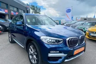 BMW X3 X-DRIVE 20 DA bleu métal en 3/4 avant droit, avec calandre chromée et plaque "OCCASION" visible.