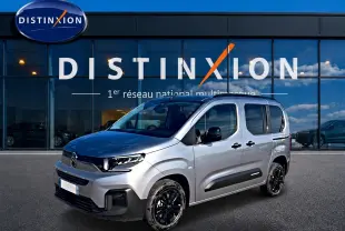 Citroën Berlingo Steel Grey vue 3/4 avant droit, avec jantes noires et barres de toit visibles.