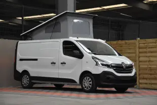 Renault Trafic Combi blanc en 3/4 avant droit avec toit relevé et carrosserie utilitaire visible en intérieur.