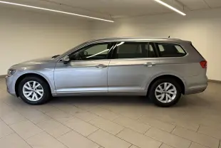 Volkswagen Passat SW 2.0 TDI 122 DSG7 Business en gris pyrite, vue profil côté gauche dans un intérieur neutre.