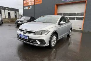 Volkswagen Polo 1.0 TSI Style argent métallisé vue 3/4 avant sur parking devant un garage autos.fr