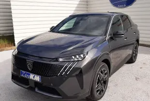 Peugeot 3008 gris titane avec toit noir, vue 3/4 avant droit, calandre noire et feux LED distinctifs.