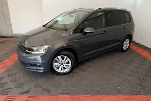 Volkswagen Touran gris clair vu en 3/4 avant droit, avec jantes alliage et vitres teintées.