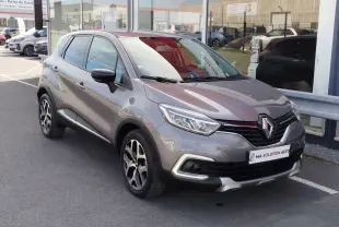 Renault Captur gris Cassiopée en 3/4 avant droit, mettant en valeur ses phares LED et jantes bi-ton.