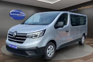 Vue 3/4 avant droit d'un Renault Trafic Combi gris platine 2023 avec calandre chromée et vitres teintées.