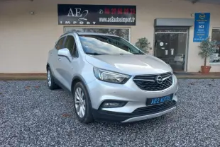 Opel Mokka X gris 2017 en 3/4 avant droit, avec calandre noire et jantes alliage visibles.