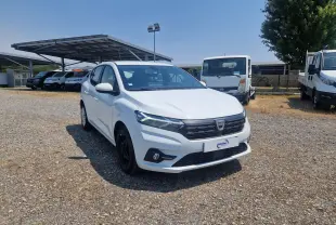 Vue 3/4 avant gauche d'une Dacia Sandero blanche 2022, avec calandre noire et feux LED distinctifs.