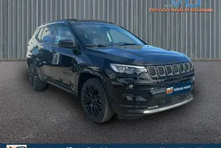 Jeep Compass noir en 3/4 avant droit, avec barres de toit et jantes alliage noires, stationné devant un mur métallique.