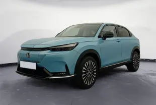 Vue 3/4 avant droite du Honda e:Ny1 204 ch Advance bleu électrique avec jantes distinctives et toit noir.
