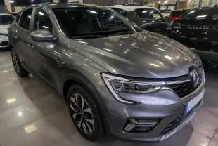 Renault Arkana gris métal en 3/4 avant droit, mettant en valeur ses phares LED et jantes bi-ton 17 pouces.