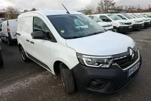 Renault Kangoo blanc en 3/4 avant droit, avec pare-chocs noir et calandre distinctive, stationné en extérieur.