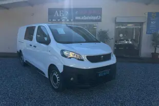 Peugeot Expert Fourgon blanc vu en 3/4 avant droit, avec calandre noire et jantes tôles, stationné devant un garage.
