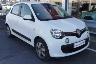 Renault Twingo blanc cristal vue 3/4 avant droit, compacte avec phares ronds et calandre noire distinctive.