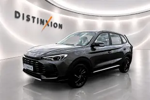 MG ZS 1.5 hybrid Camden grey en 3/4 avant droit, avec jantes noires et calandre marquée dans un showroom lumineux.