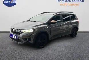 Vue 3/4 avant droit d'un Dacia Jogger gris schiste métallisé avec jantes noires et rétroviseurs couleur bronze.