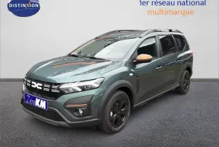 Vue 3/4 avant droite du Dacia Jogger 2026 vert cèdre métallisé avec rétroviseurs beige et jantes noires.