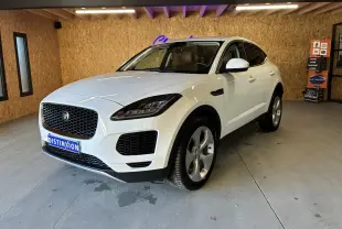 Jaguar E-PACE blanc en 3/4 avant droit dans un garage, avec calandre noire et jantes argentées.