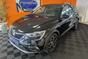 Renault Arkana noir en 3/4 avant droit, avec jantes bi-ton et calandre chromée dans un showroom orange.