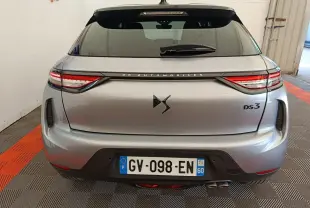 Vue arrière d'une DS3 gris foncé 2024 avec feux LED et double sortie d'échappement visible en intérieur showroom.