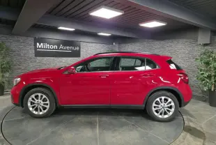 Mercedes GLA 200 d rouge vue de profil côté gauche, avec jantes alliage 17 pouces et attelage rabattable visible.