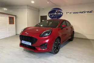 Ford Puma rouge vue 3/4 avant droit en intérieur, avec calandre noire et jantes alliage noires distinctives.