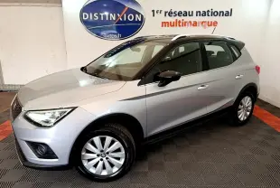 SEAT Arona gris clair vue 3/4 avant droit en intérieur, avec toit noir et jantes alliage.