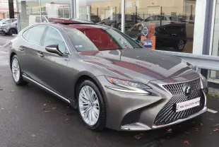 Lexus LS 500H gris manganèse vue 3/4 avant, mettant en valeur sa calandre distinctive et ses jantes élégantes.