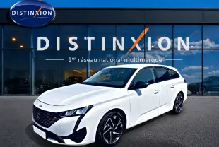 Peugeot 308 SW blanche vue en 3/4 avant droit, avec jantes alliage noires et calandre noire distinctive.