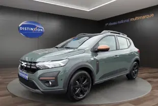 Vue 3/4 avant droite d'une Dacia Sandero Stepway 2025 kaki lichen avec rétroviseurs couleur cuivre et jantes noires.